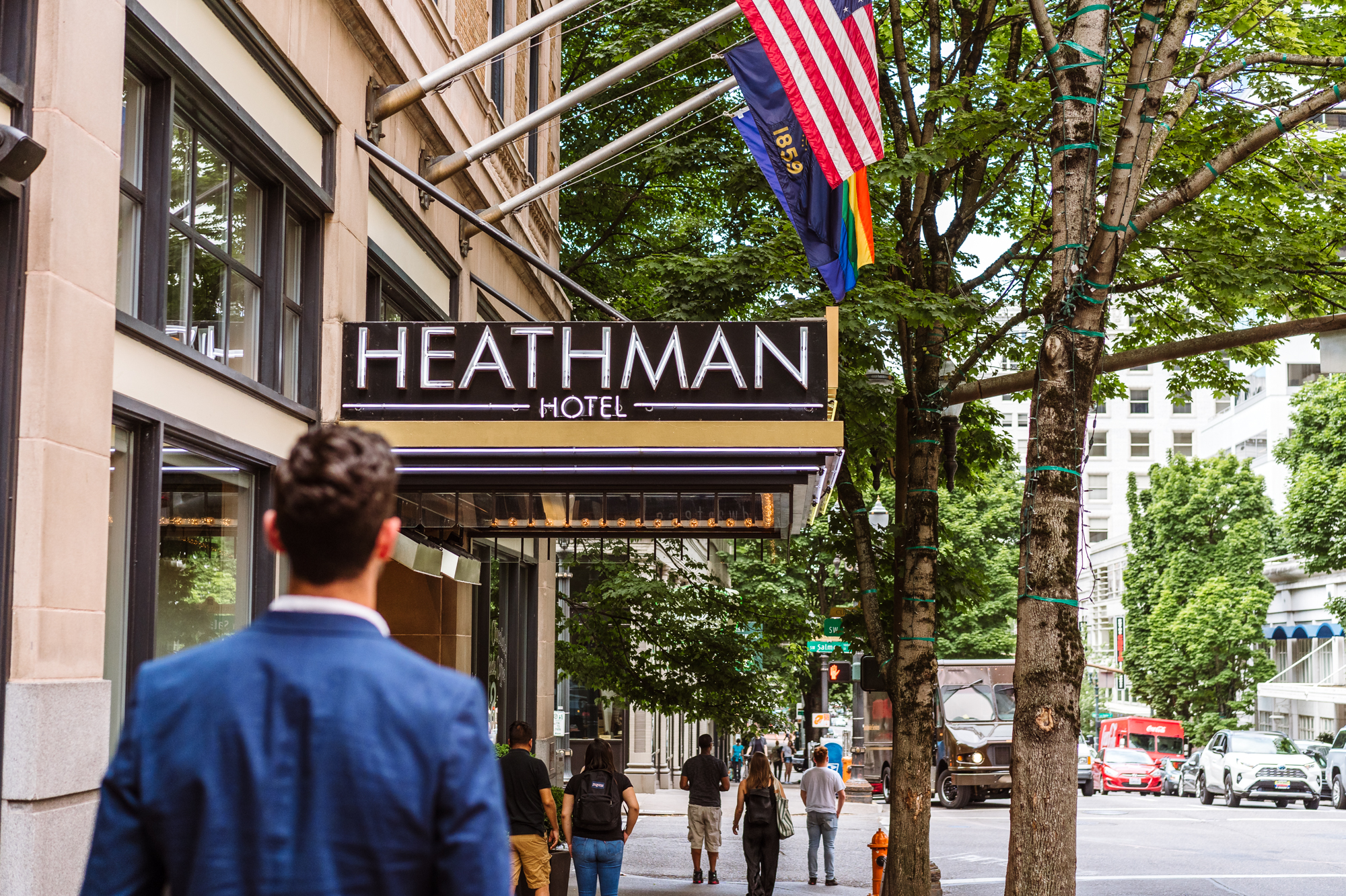 man walking down the street toward Heathman Hotel entrance