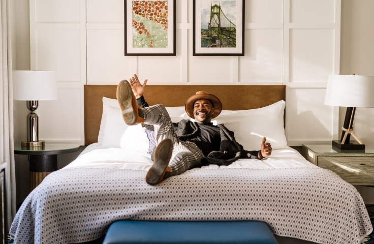 A man enjoying his hotel room at the Heathman Hotel in Portland, Oregon.