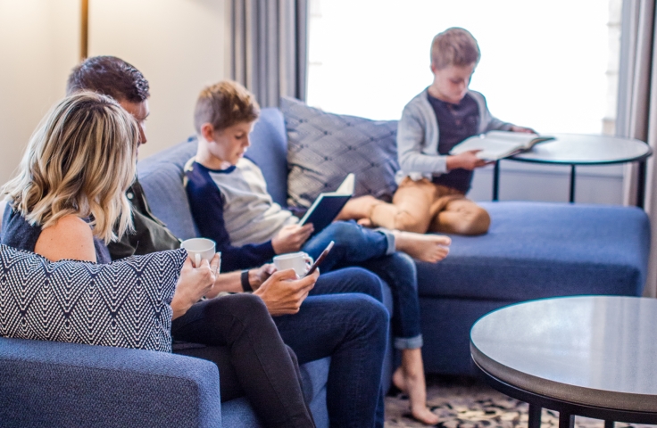 A family sitting in the living area of a hotel suite.