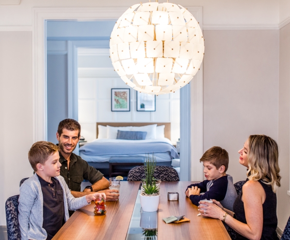 A family sitting in the dining area of the Heathman Hotel's penthouse suite.