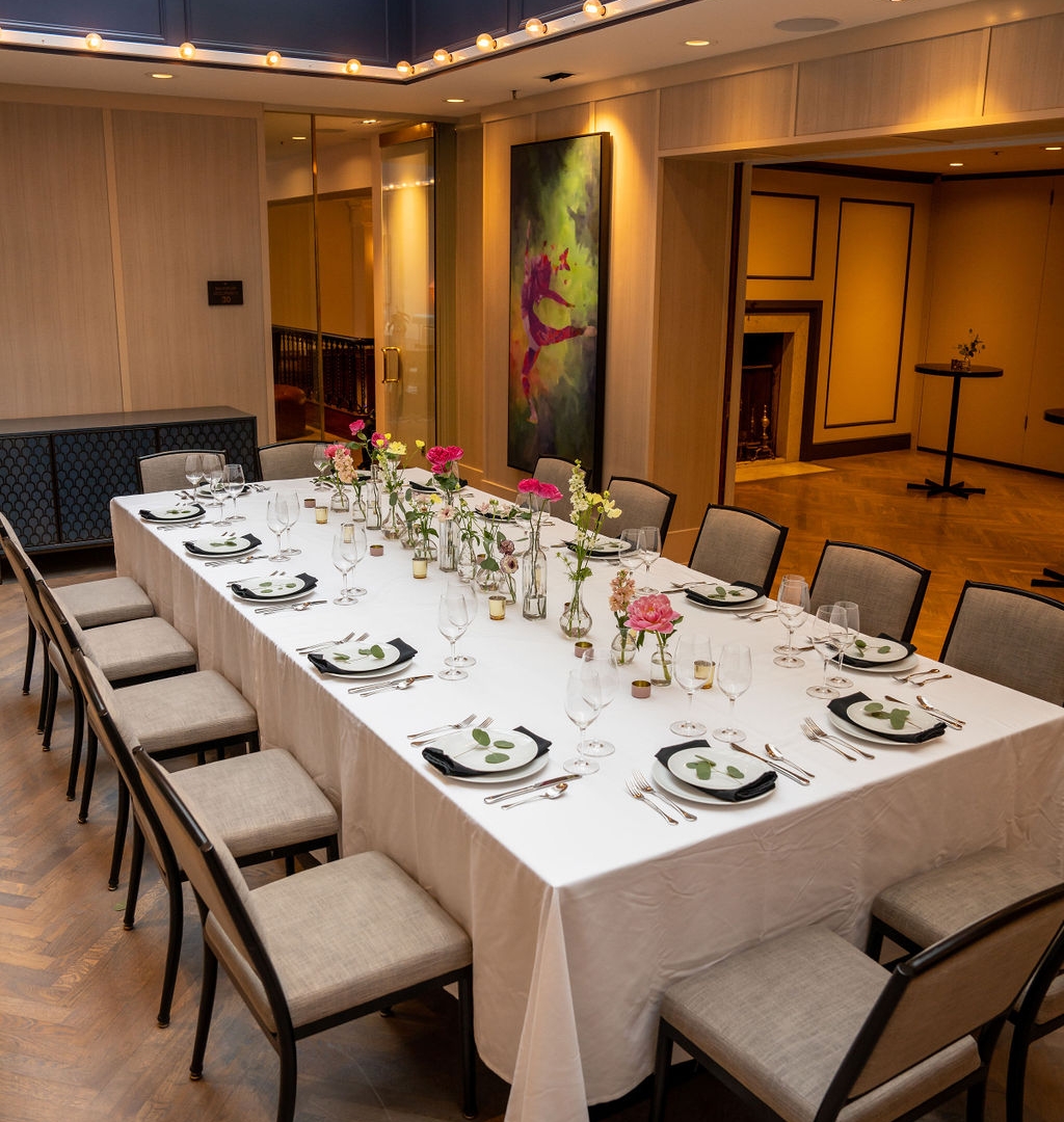 A long dining table set for a dinner event in the Opus event room at the Heathman Hotel.