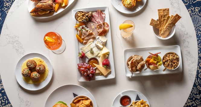 An aerial view of different plates of food on a round table.